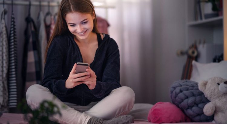 young girl using her smartphone while browsing profiles on a dating app